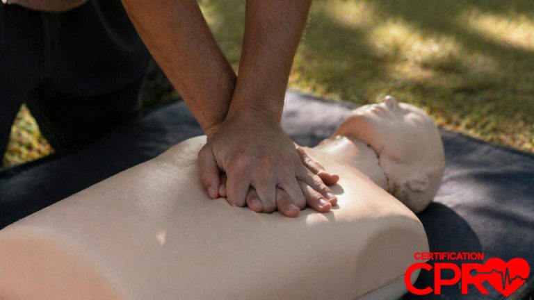 Person performing hands-only CPR on a mannequin outdoors in Laredo.